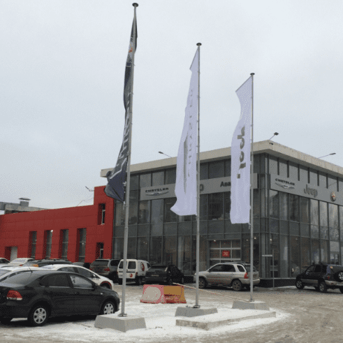 Рекламные г-образные флаги разных компаний у торгового центра